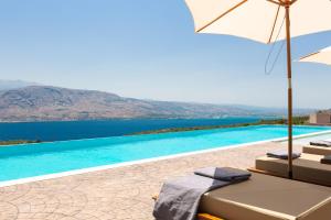 a swimming pool with a view of the water at Elements Villa in Galangádhos