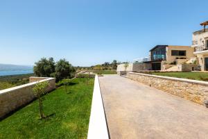 a walkway next to a stone wall and a building at Elements Villa in Galangádhos