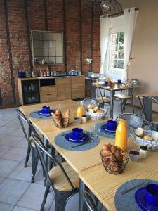 una cucina con tavoli in legno, lastre blu e pane di Le Clos a Hucqueliers