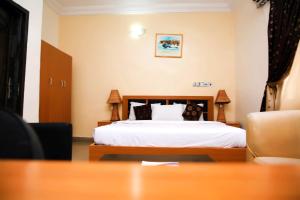 a hotel room with a bed and a table at Western Dreams Hotel in Abuja