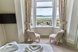 a room with two beds and a large window at The Commodore Inn in Grange Over Sands