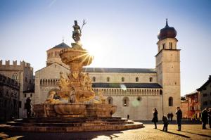 a fountain in front of a castle with people walking around it at Al Belenzani Appartamento in Trento