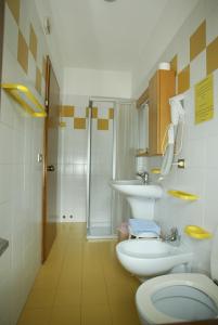y baño con aseo, lavabo y ducha. en Albergo Garni Barancio, en Auronzo di Cadore
