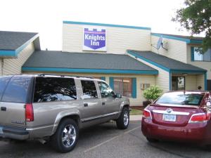 Un todoterreno estacionado en un estacionamiento frente a una posada nacional en Knights Inn Litchfield, en Litchfield