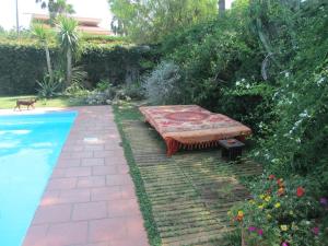 a garden with a bench next to a swimming pool at Sole e Sale B&B in San Cataldo