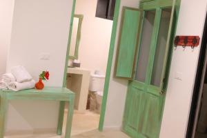 a bathroom with a green door next to a toilet at Punta Piedra Beach Posada in Tulum