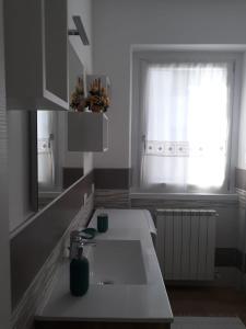 a white kitchen with a sink and a window at Appartamento Alba in Selvino