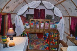 ein Schlafzimmer mit einem Bett in einem Zelt in der Unterkunft The Wonderly Wagon in Fintown