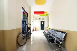 a hallway with chairs and a bike on the wall at RedDoorz @ Jalan STM Medan in Medan