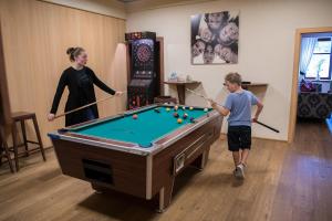 Eine Frau und ein Mann spielen Billard mit einem Billardtisch in der Unterkunft Seegasthof Breineder - Familien & Seminarhotel in Mönichwald