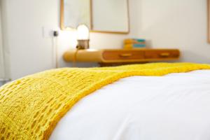 a yellow blanket laying on top of a bed at The Lerryn in Falmouth