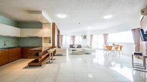 a large kitchen and living room with a white tile floor at Markland Seaside Pattaya in Pattaya