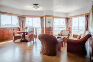 a living room with a couch and chairs and a table at Markland Seaside Pattaya in Pattaya +24 photos