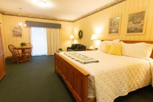 a hotel room with a large bed and a table at Essenhaus Inn & Conf. Center in Middlebury