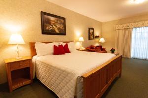 a bedroom with a large bed with red pillows at Essenhaus Inn & Conf. Center in Middlebury