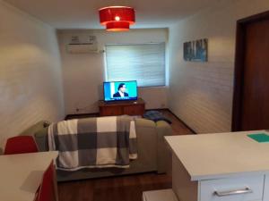 uma sala de estar com um sofá e uma televisão em Dianella · Affordable & comfortable close to the city & shops em Perth