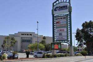 una señal para un concesionario de coches con coches estacionados en un estacionamiento en Dianella · Affordable & comfortable close to the city & shops, en Perth