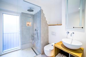 uma casa de banho com um lavatório e uma cabina de duche em vidro. em MEMENTO B&B Piran em Piran