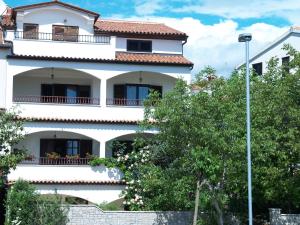 un edificio blanco con árboles delante de él en Apartments Frank, en Rovinj