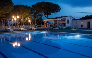 una piscina por la noche con una casa en Camping Roca Grossa, en Calella