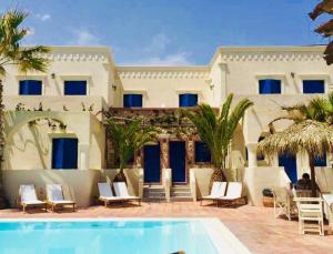 a resort with a swimming pool in front of a building at The Boathouse Hotel in Kamari