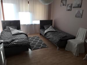 1 dormitorio con 2 camas, silla y alfombra en Horyzont, en Lublin