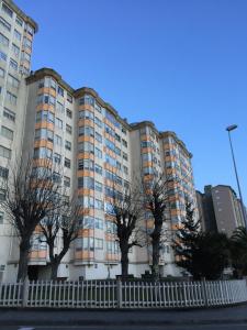 a tall building with trees in front of it at APARTAMENTO 10 PISO VISTAS AL MAR in Ferrol