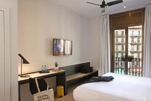 a bedroom with a bed and a desk at Chic & Basic Lemon Boutique Hotel in Barcelona