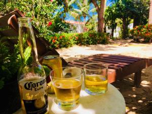 a bottle of beer and two glasses on a table at Casa Jeri in Jericoacoara