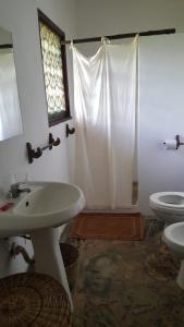 a bathroom with a sink and a toilet and a shower at Eco Villas Watamu in Watamu