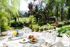 a table with plates of food on top of it at Waterland Lodge in Hout Bay