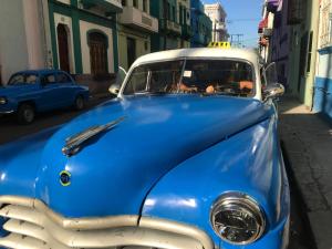 an old blue car parked on a street at Casa Estrella Azul in Havana
