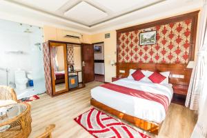 Un dormitorio con una cama grande y un baño. en Hotel Pokhara Goodwill, en Pokhara