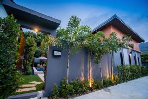 a house with palm trees in front of it at The Sister Pool House in Bang Tao Beach