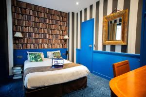 une chambre d'hôtel avec un lit et une porte bleue dans l'établissement Hôtel du Théâtre by Patrick Hayat, à Paris
