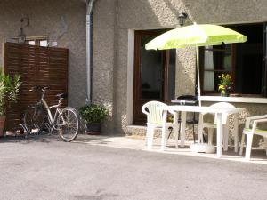 een tafel en stoelen en een parasol naast een fiets bij Escale du château de Promery 1389 in Annecy