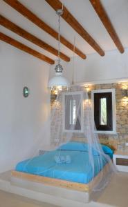 a bedroom with a blue bed with a net at STUDIOSWORX Apartments in Ios Chora
