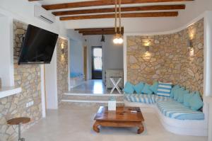 a living room with a blue couch and a stone wall at STUDIOSWORX Apartments in Ios Chora