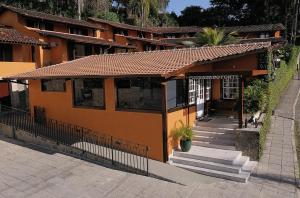 ein kleines orangefarbenes Gebäude mit einer Treppe davor in der Unterkunft Pousada Do Forte in Paraty