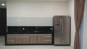 a kitchen with a stainless steel refrigerator in a room at SleepRest @ Nagoya Valley in Nagoya