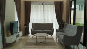 a living room with two chairs and a tv at SleepRest @ Nagoya Valley in Nagoya