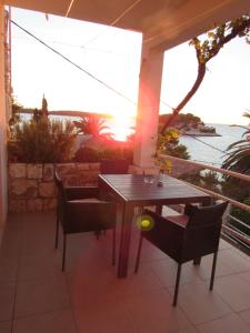 una mesa y sillas en un patio con vistas al océano en Apartments Bicanic, en Hvar