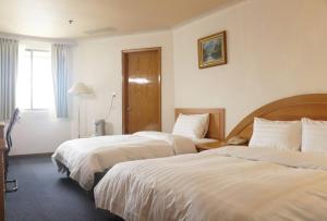 Een bed of bedden in een kamer bij Oriental Hotel
