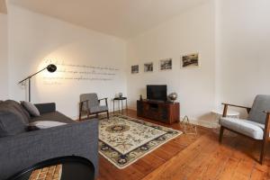 a living room with a couch and a tv at Chiado Views by Homing in Lisbon