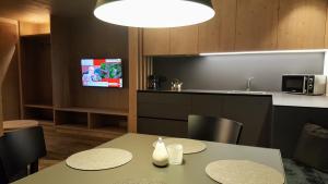 a kitchen with a table and chairs and a tv at Residence Forcelles in San Cassiano
