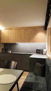 a kitchen with wooden cabinets and a table and a couch at Residence Forcelles in San Cassiano