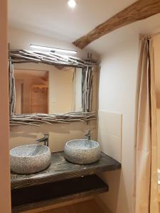 two sinks in a bathroom with a mirror at La chenevière in Saint-Rémy-de-Chargnat