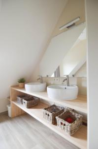 a bathroom with two sinks in the attic at Fermette de bobonne in Poperinge