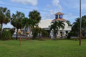 una casa blanca con una torre de reloj en el patio en Americas Best Value Inn Fort Myers en Fort Myers