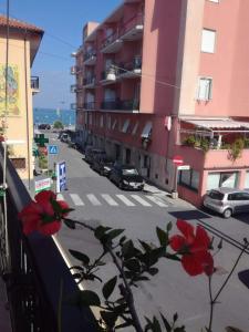 a view of a street from a balcony with red flowers at Casa Gemma in Diano Marina